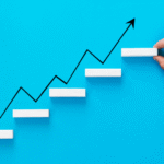 f7b51dda-businessman-arranging-wooden-blocks-stacking-as-step-stair-with-growth-arrow-1.png
